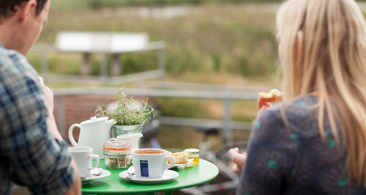 Couple enjoying cup of tea and coffee outside